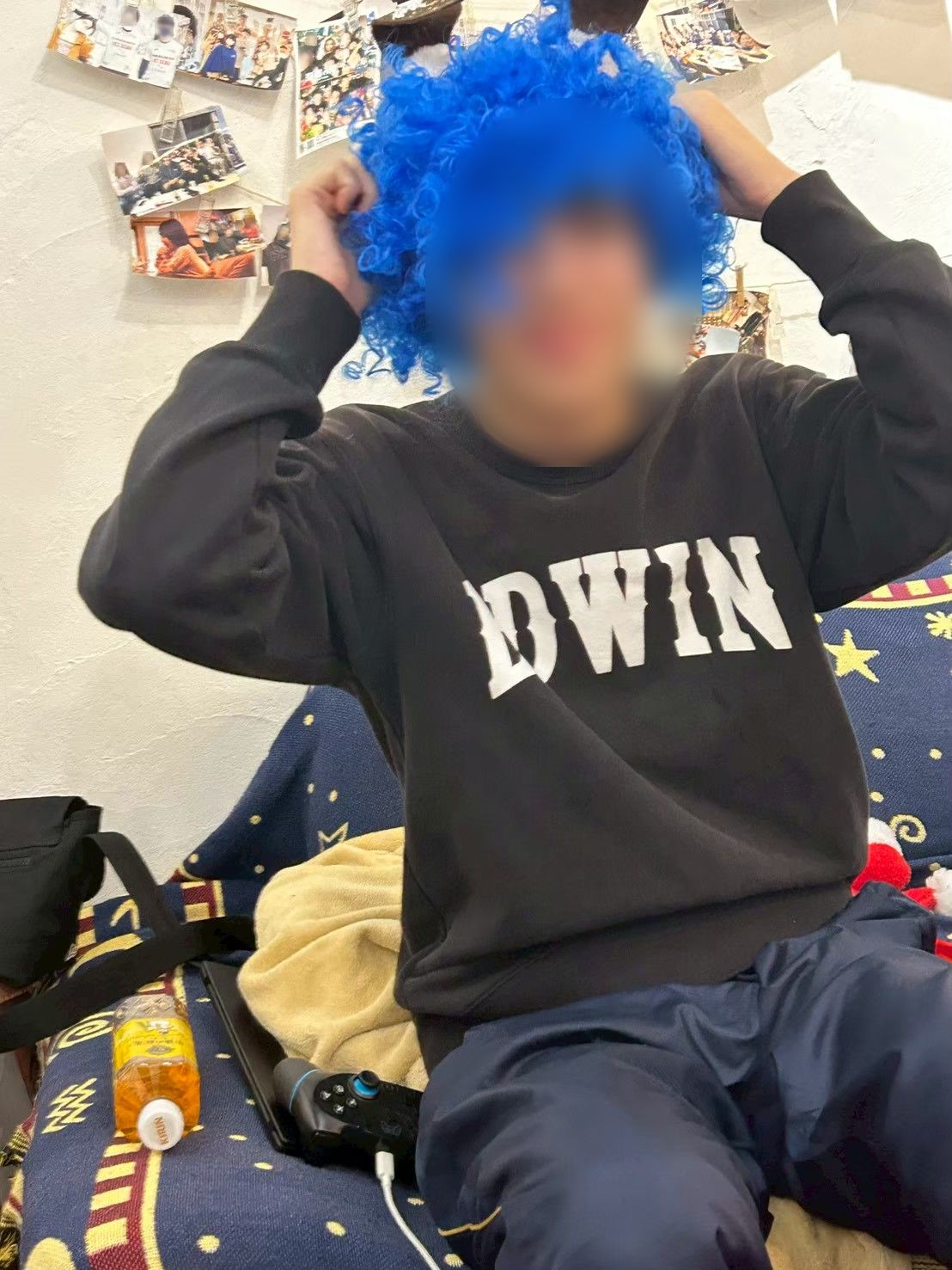青いアフロウィッグをかぶっておどける住人
