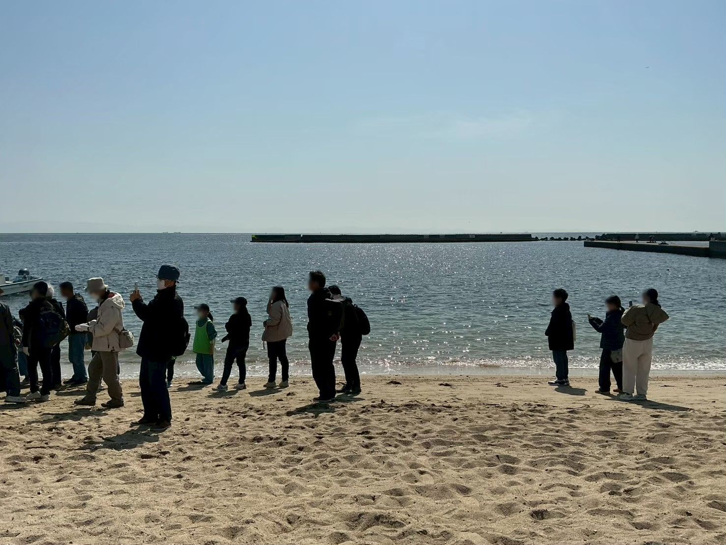 須磨海岸の砂浜に立つ住人たち